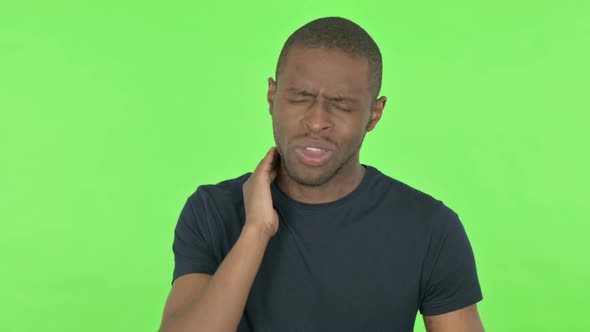 Young African Man with Neck Pain on Green Background