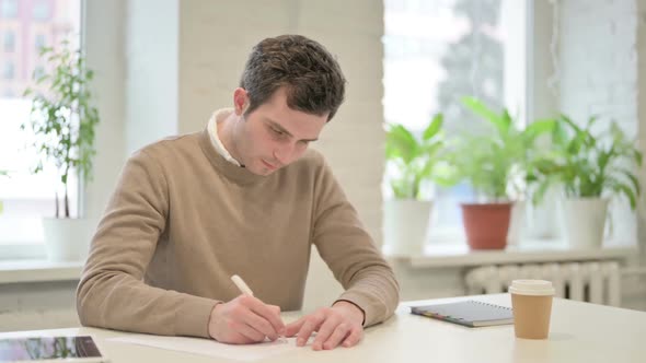 Man Having Disappointment While Writing on Paper