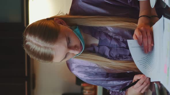 Woman in Pajama and with Medical Mask Signing Documents