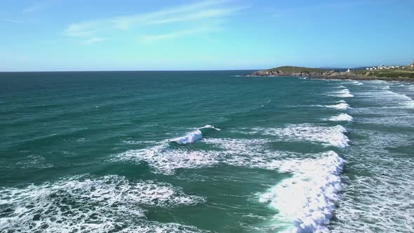 Aerial side-shot of a surfer catching a wave at Fistral beach, Newquay, Cornwall