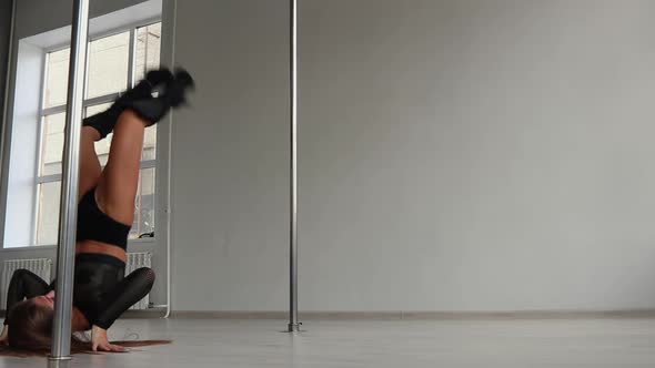 Flexible Woman Dancing on Pole in Studio