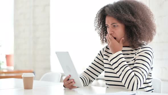 African Woman Reacting To Loss on Tablet 