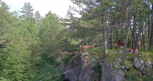 A man falls while slacklining on a tightrope in the mountains