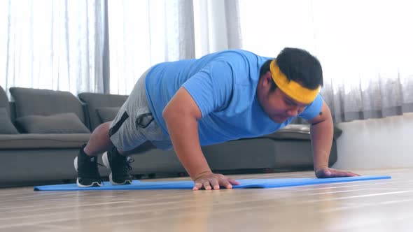 Plump Male Struggling To Do Push Ups At Home