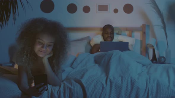 Family Couple Using Gadgets in Bed