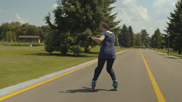 Skillful Female Rollerblading Backwards Outdoors