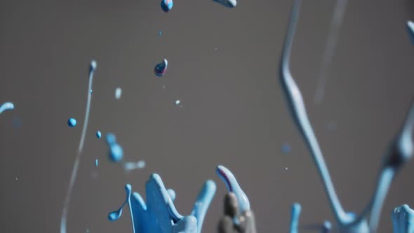 Blue Paint Splashing And Creating Droplets And Abstract Shapes