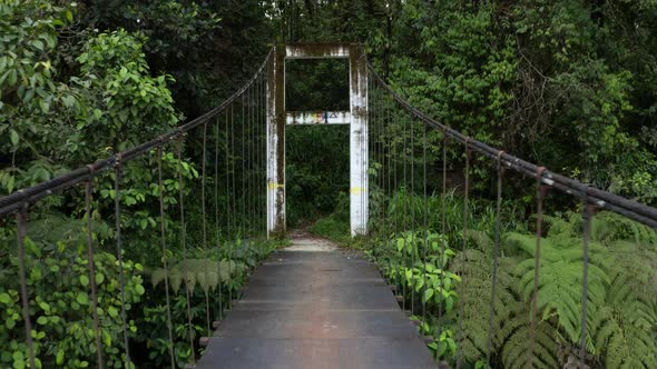 Going backwards over a large metal pedestrian bridge revealing the river