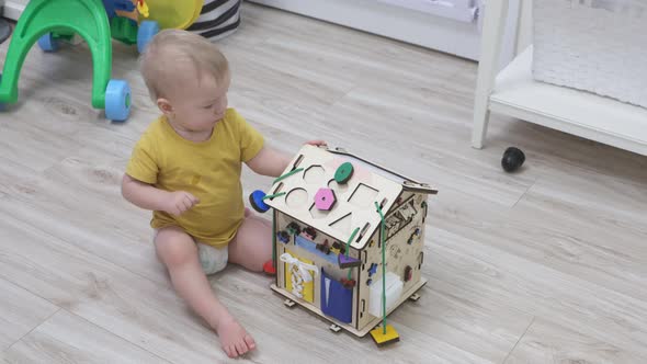 Child Having Fun Playing with Wooden Busy Board Happy Kid Play with Educational Learning Toy Enjoy