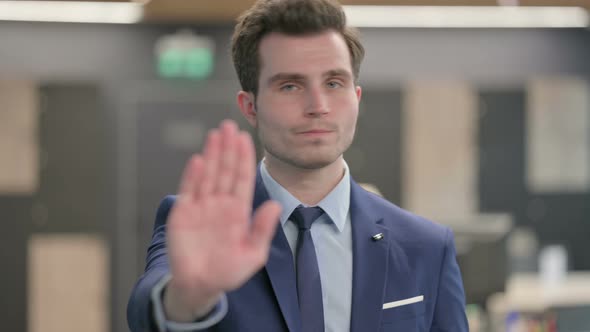 Portrait of Businessman Showing Stop Sign By Hand