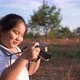 Girl standing in meadow with camera - VideoHive Item for Sale