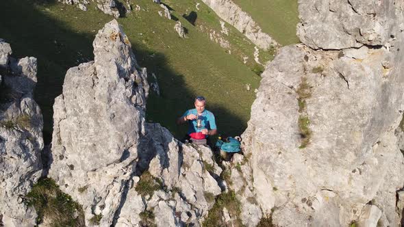 Hiker preparing mocha on rocks, Lecco, Italy