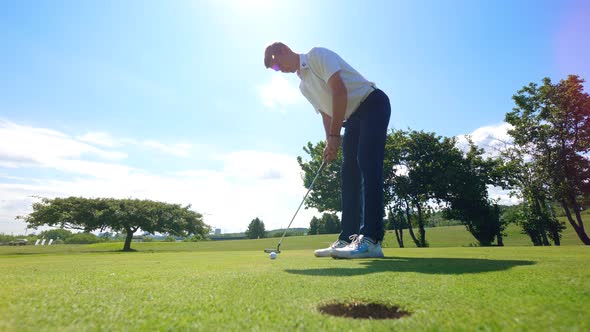 Male Player Is Striking and the Ball Is Falling Into the Hole