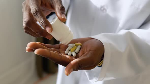 African American Doctor Pouring on Hand Pills From Meds Bottle