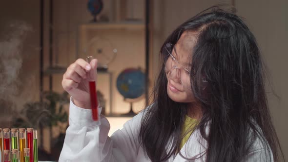 Young Scientist Girl With Dirty Face Looking At Liquid In Test Tube