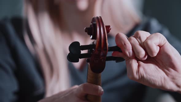 Young Blonde Woman Tuning the Violin Before Playing