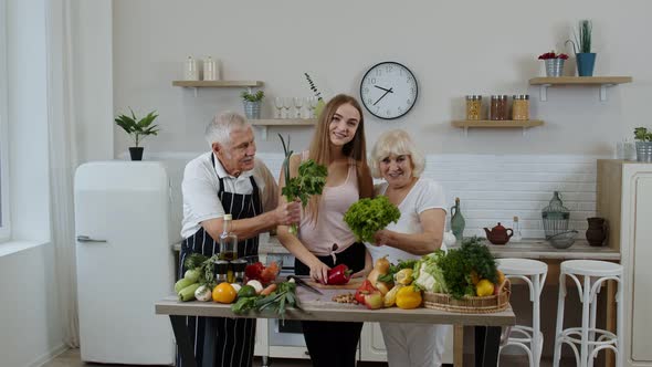 Grandchild Girl with Senior Grandparents Recommending Eating Raw Vegetable Food. Nutrition Diet