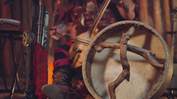 Man Plays Igil on Stage Focus on Shamanic Tambourine