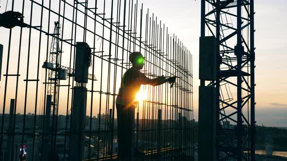 Workers Move Metal Poles While Building a House on a Site alt