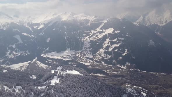 Aerial drone shot high over the snow covered slopes and town of Verbier, Switzerland.