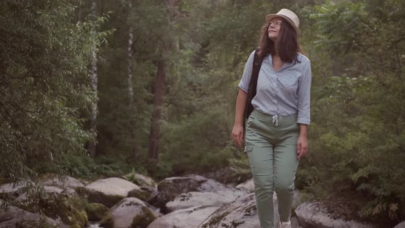 Woman Traveler Walks on Huge Stones in Nature