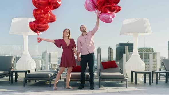 Slow Motion Beautiful Young Romantic Couple with Bunch Huge Red Hearts Balloons