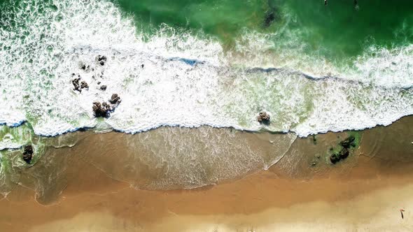 Tropical Sea Waves Hitting Sandy Beach with Sun Reflection, Aerial Top Down View