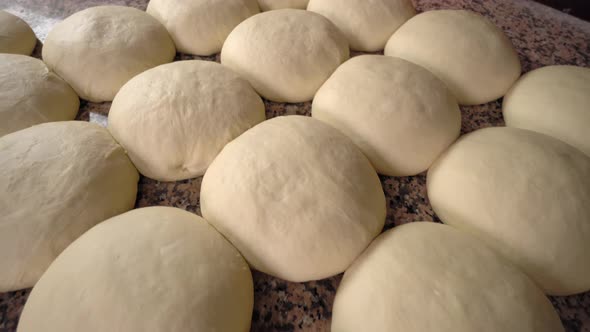 Raw yeast balls for background dough in frying pan before baking.