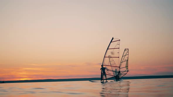 Men on Windsurf Boards Are Managing Sails While Floating