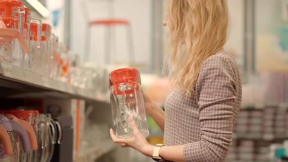 Woman Purchaser In Store Chooses Carafe. Girl In Supermarket Shopping And Choose Gift. Store Market.