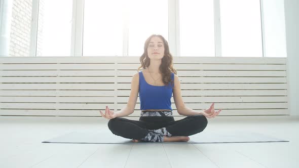 Yoga and Home Workouts Concept. Young Woman Meditates While Practicing Yoga Indoors