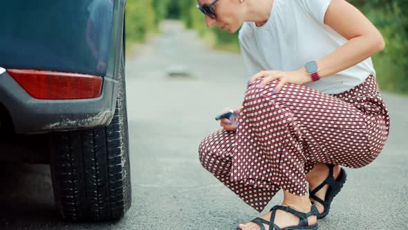 Woman Check Car Tire Pressure. Vehicle Trouble On Road On Vacation Trip. Female Trying Fix Car Tire.