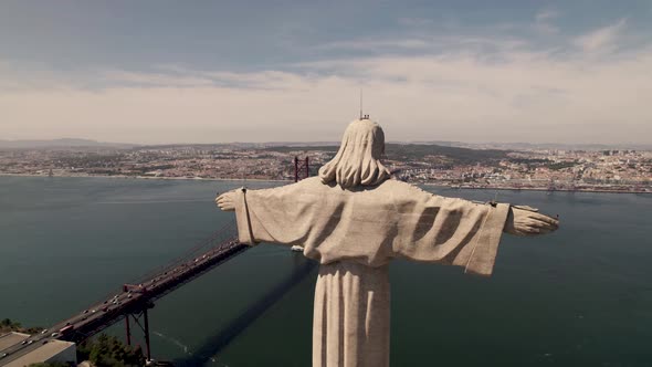Outstretched arms of Christ the King overlooking Lisbon and Tagus River. Circling shot