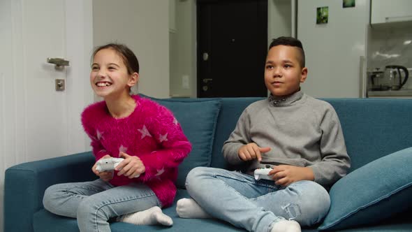 Multiethnic Preteen Friends Competing By Playing Video Game Indoors