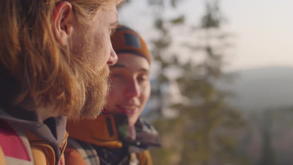 Couple Discussing Scenic View of Winter Woods from Mountain