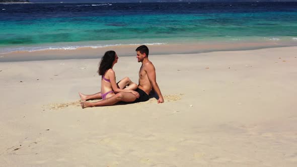 Romantic couple tan on beautiful coast beach wildlife by blue ocean and white sand background of Bal