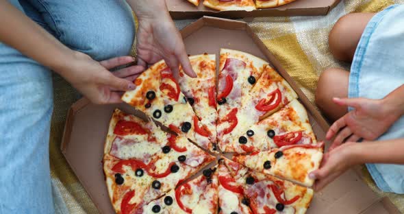 Sharing Pizza Hands Taking a Piece of Pizza From a Box Outdoor