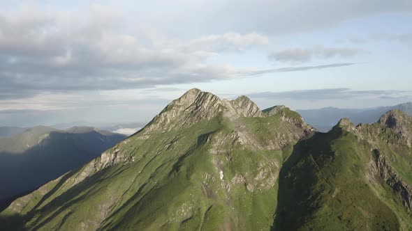 Natural Mountain Peak Cliff Terrain at Sun Light Surrounded Cloudy Blue Sky Organic Landscape