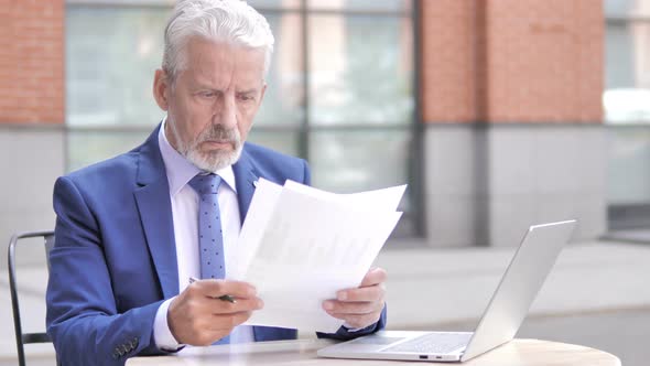 Old Businessman Reading Documents Outdoor