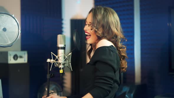 Girl singing to the microphone in a studio. Female vocal.