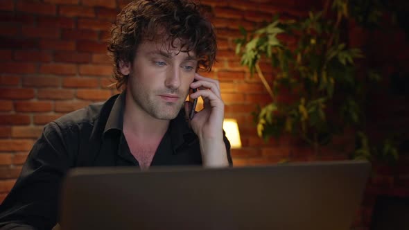 Young Successful Businessman Speaking on Phone Working in Office at Night