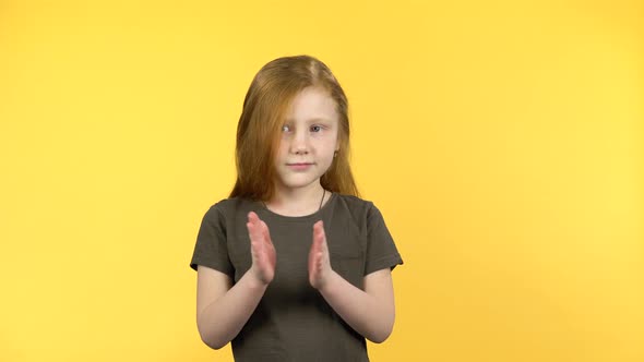 Pretty Girl Claps Happily on Yellow Background