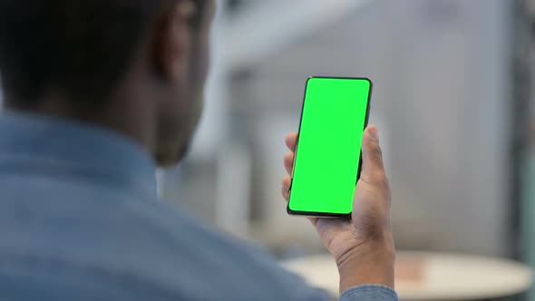 Man Looking at Smartphone with Green Chroma Key Screen