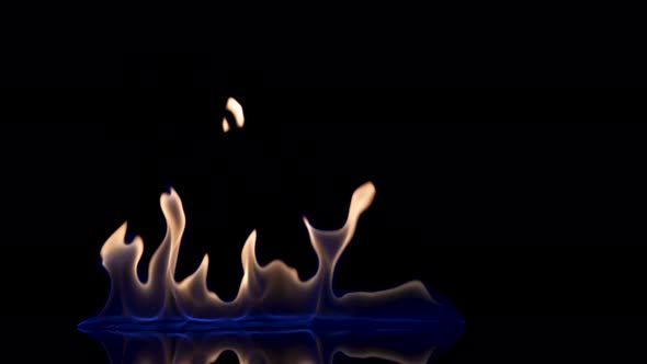 Flash and Fire Streak of Flammable Liquid or Gasoline Against Black Reflective Background