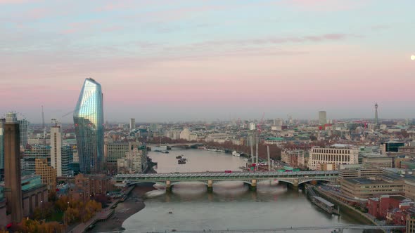 Dolly forward aerial of millennium and Blackfriars bridge over Thames river early morning sunrise