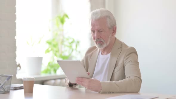 Old Man Using Tablet While Sitting in Office