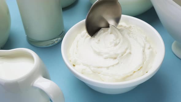 Whipped cream with spoon on blue background, top view