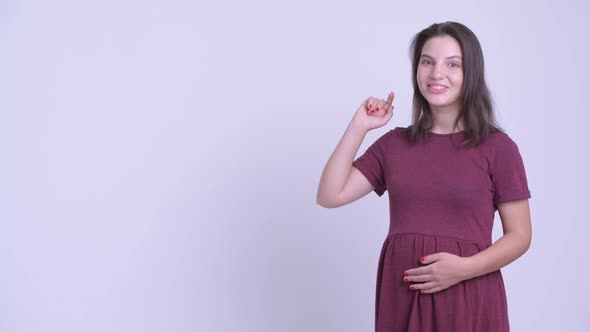 Happy Young Beautiful Pregnant Woman Touching Something and Looking Excited