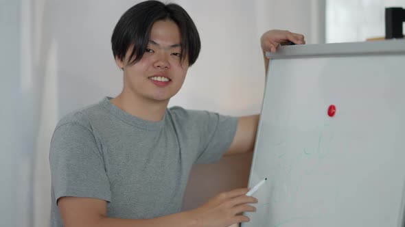 Young Asian Man Turning to Camera with Toothy Smile