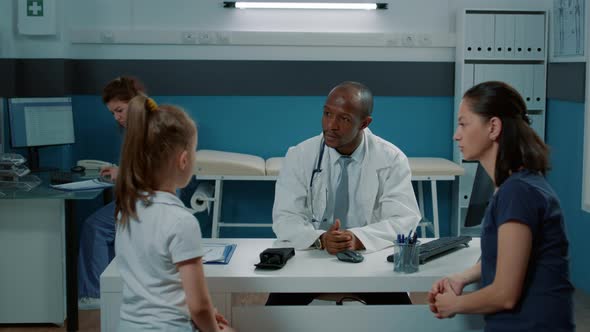 African American Medic Talking to Small Patient and Mother